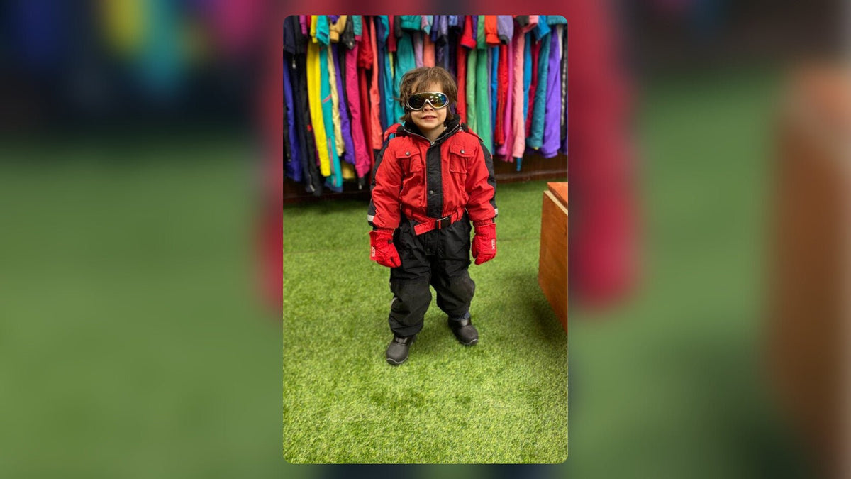Niño con kit de ropa de nieve, antiparras y guantes listo para su día en la nieve cerca de Santiago