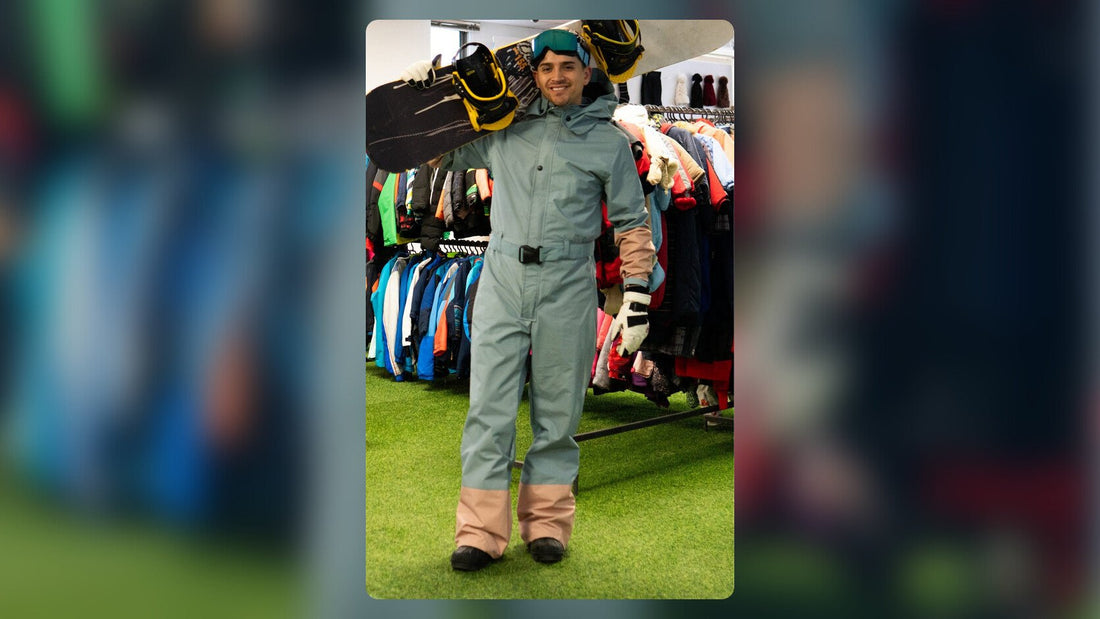 Joven con tabla de snowboard arrendada y enterito de nieve en la tienda Andes Premier Rental en Las Condes