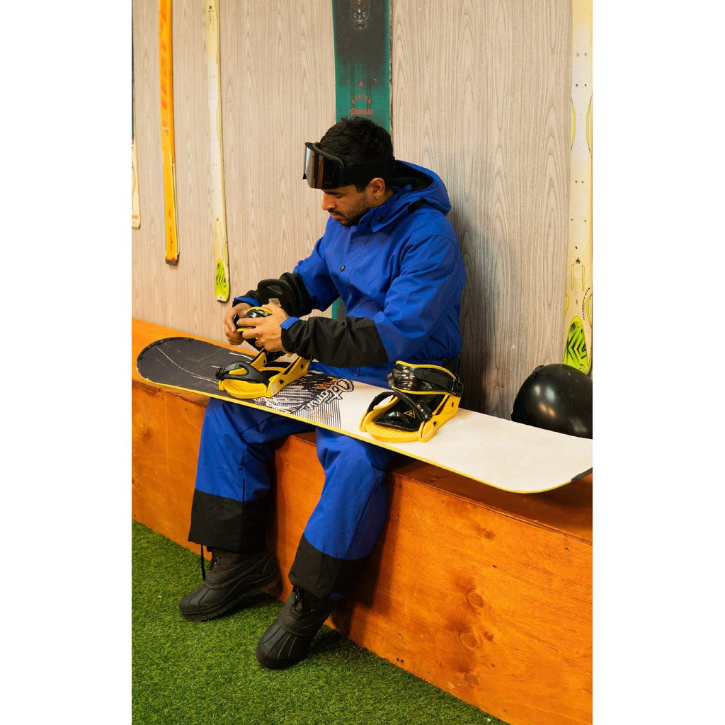 Ajustando las fijaciones de la tabla de snowboard en la tienda Andes Premier Rental