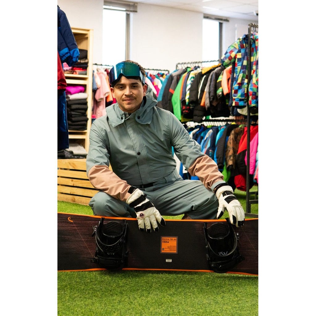 Guantes de nieve adulto con enterito y tabla de snowboard en la tienda de Las Condes